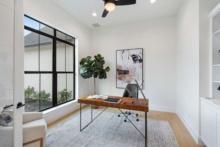A home office with minimalist modern décor, a neutral color palette, and ample natural lighting.