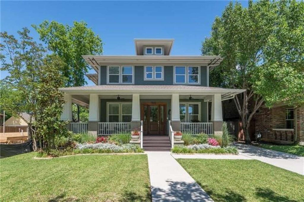 A green Airplane Craftsman Bungalow home with white accent trim and a large front porch