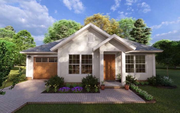 A white 800 sq ft house with natural wood doors and a colorful flower garden in the front yard.