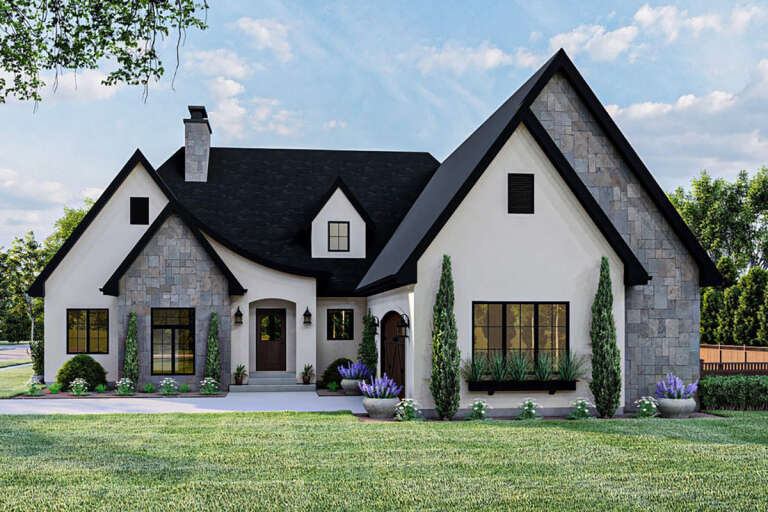 A white, contemporary Modern Tudor-style house with a natural stone façade.