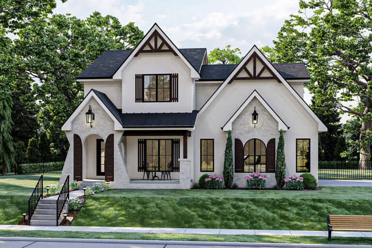 A white, modern Tudor-style house with a white stone façade and dark wood shutters.