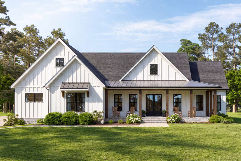 White Modern Farmhouse, Front Elevation, board-and-batten siding, metal roof, wood porch posts, rockers, landscaping. House Plan # 009-00524 Digital Rendering by America's Best House Plans, Inc.