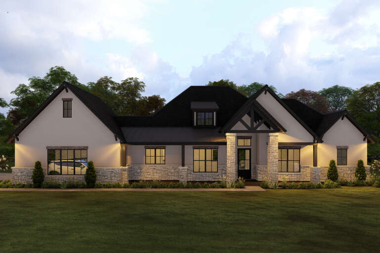 Beige Craftsman, Front Elevation at Dusk, stone base, dark metal roof, timber accents, lit porch, and manicured lawn. House Plan # 3571-00041 Digital Rendering by America's Best House Plans, Inc.