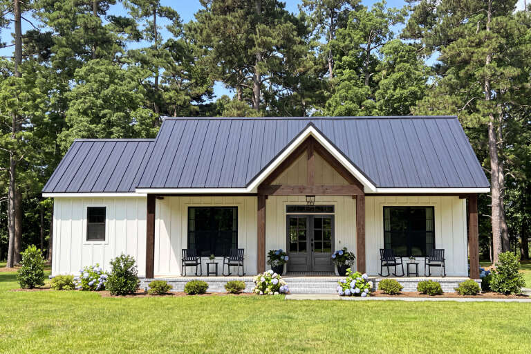 White Modern Farmhouse, Front Elevation, board-and-batten siding, metal roof, timber porch, brick base, hydrangeas. House Plan # 009-00529 Digital Rendering by America's Best House Plans, Inc.