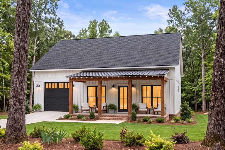 White Barndominium, Angled Front Elevation, board-and-batten siding, timber porch, black metal roof, and lush landscaping. House Plan # 041-00451 Digital Rendering by America's Best House Plans, Inc.