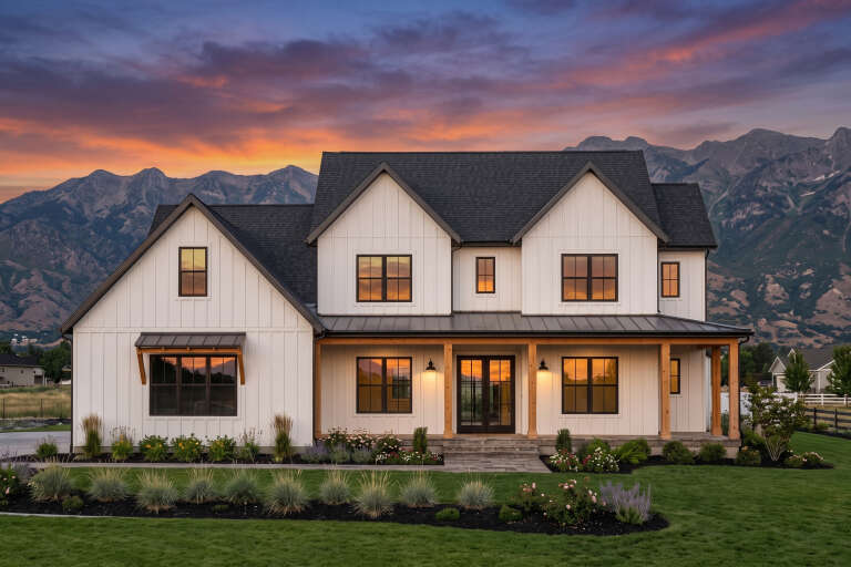 White Modern Farmhouse, Front Elevation at sunset, board-and-batten siding, wood porch posts, lit sconces, mountain view. House Plan # 7983-00203 Digital Rendering by America's Best House Plans, Inc.