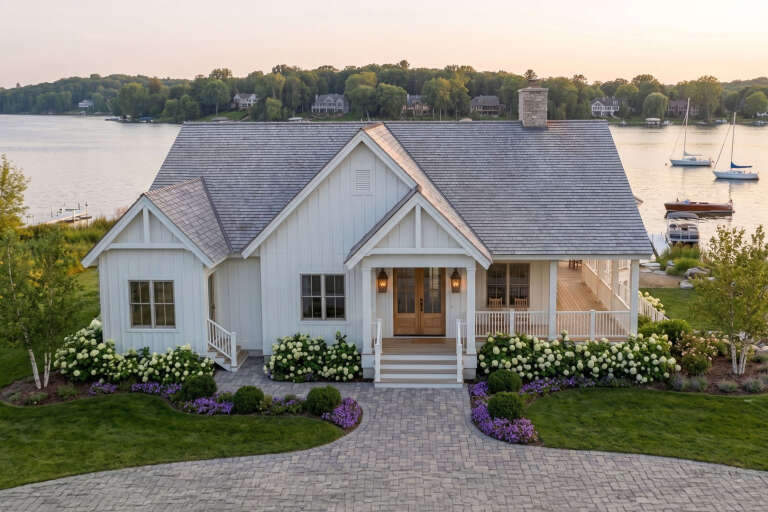White Cottage, Front Elevation, board-and-batten siding, cedar roof, wood door, lantern lights, stone path, lakefront view. House Plan # 963-01319 Digital Rendering by America's Best House Plans, Inc.