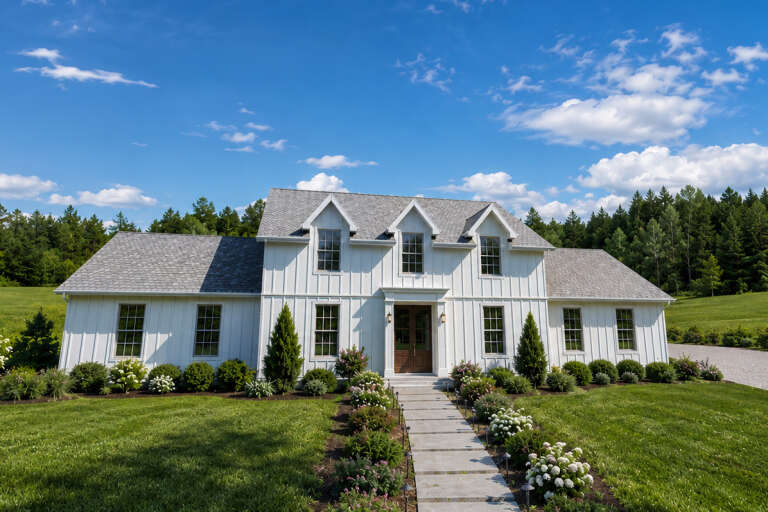 White Modern Farmhouse, Angled Front Elevation, board-and-batten siding, stone walkway, wooden door, lush landscaping. House Plan # 1625-00001 Digital Rendering by America's Best House Plans, Inc.