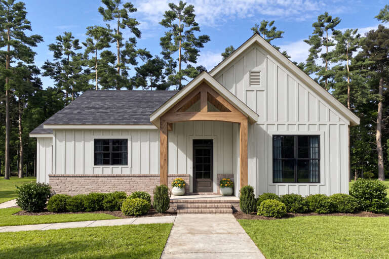 White Modern Farmhouse, Front Elevation with board-and-batten siding, brick base, timber porch, and manicured landscaping. House Plan # 009-00532 Digital Rendering by America's Best House Plans, Inc.