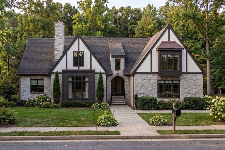White Tudor, Front Elevation with stone siding, timber accents, arched entryway, copper bay roof, and lush landscaping. House Plan # 963-01321 Digital Rendering by America's Best House Plans, Inc.