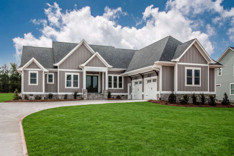 Grey Modern Farmhouse, Angled Front Elevation, vertical siding, stone base, white trim, garage lights, green lawn. House Plan # 6102-00002 Digital Rendering by America's Best House Plans, Inc.