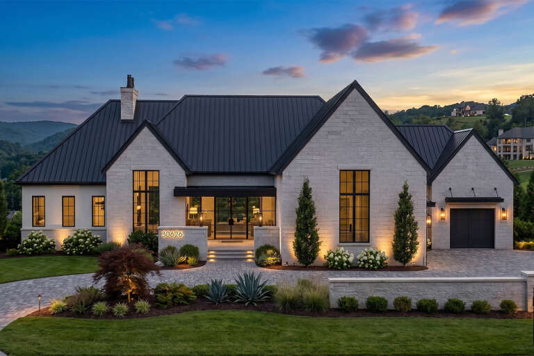 Grey Modern Transitional, Front Elevation at Dusk, stone siding, metal roof, lit windows, pavers, and manicured landscape. House Plan # 963-01323 Digital Rendering by America's Best House Plans, Inc.