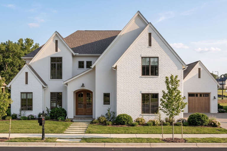 White European, Front Elevation, painted brick, arched wooden front door, dark window frames, landscaping, stone walkway. House Plan # 963-01329 Digital Rendering by America's Best House Plans, Inc.