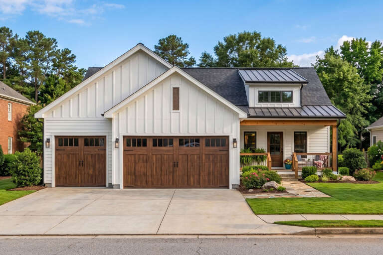 White Modern Farmhouse, Front Elevation with board-and-batten siding, wood garage doors, stone path, and metal roof. House Plan # 963-01330 Digital Rendering by America's Best House Plans, Inc.