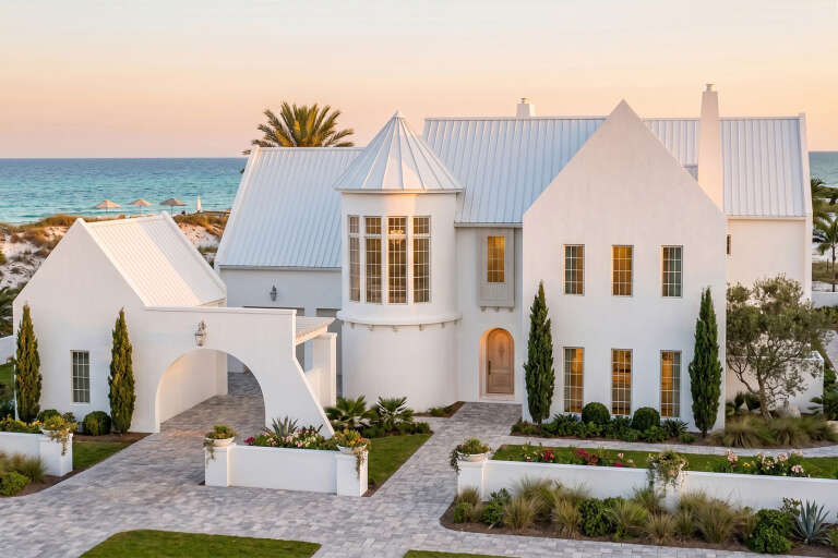White Mediterranean, Angled Front Elevation, stucco siding, metal roof, arched entry, paver driveway, coastal landscaping. House Plan # 963-01336 Digital Rendering by America's Best House Plans, Inc.