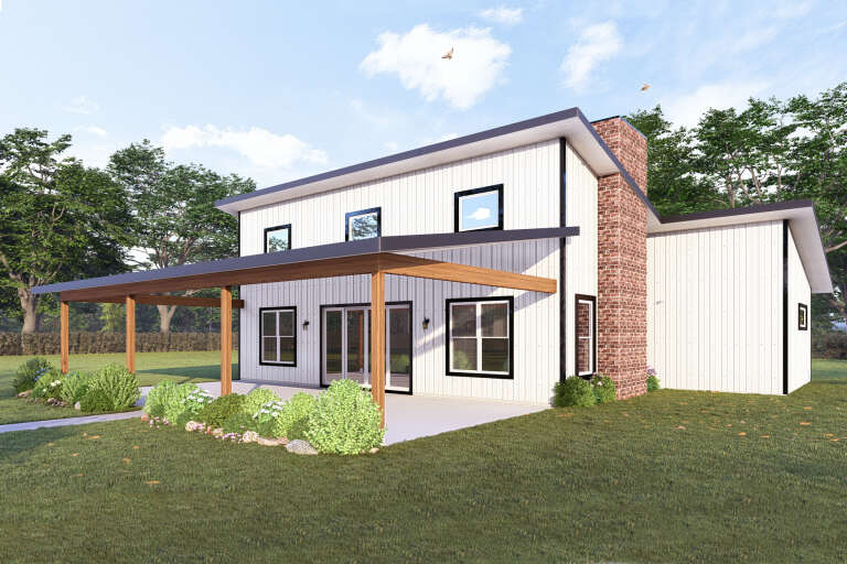 Angled rear view of a white house in Modern style, board-and-batten siding, brick chimney, and covered wood patio. House Plan # 3822-00047