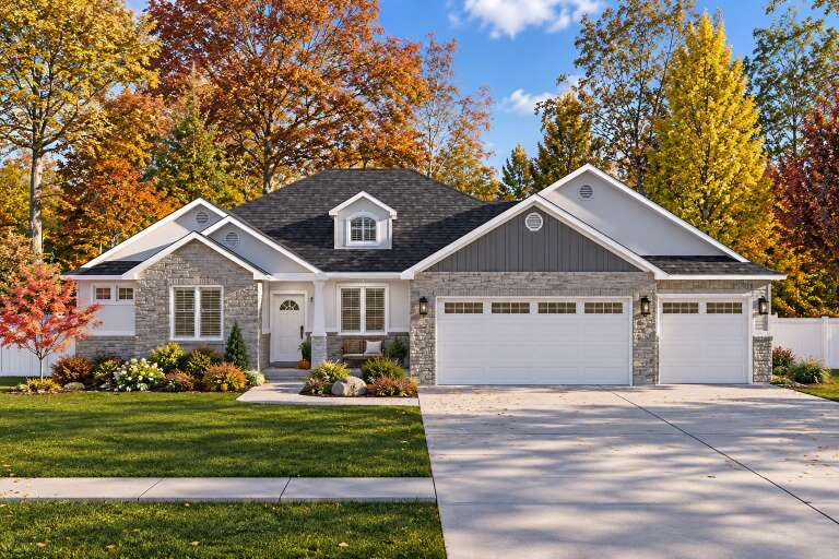 Front view of a gray Traditional house, stone and siding exterior, gabled roof, dormer, and three-car garage. House Plan # 2802-00585