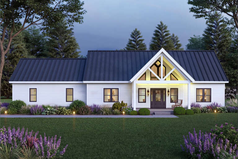 Front view of a white house in Modern Farmhouse style, metal roof, gabled entry, black windows, and lush landscaping. House Plan # 940-01490