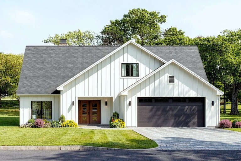 Front view of a white house in Modern Farmhouse style, board-and-batten siding, dark garage door, and wood double entry. House Plan # 3125-00057