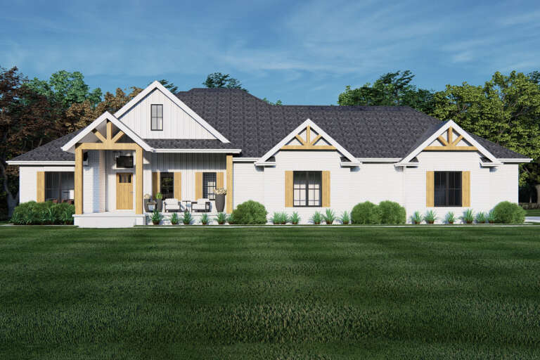 Front view of a white house in Modern Farmhouse style, brick siding, wood accents, gabled roof, and black windows. House Plan # 7140-00044