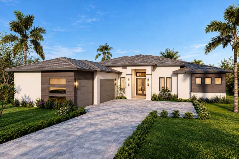 Front view of a white and wood Modern house, hip roof, paver driveway, two-car garage, and lush tropical landscaping. House Plan # 5565-00193