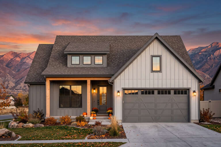 Front view of a gray and white Modern Farmhouse, board-and-batten siding, wood porch posts, and mountain backdrop. House Plan # 7983-00223