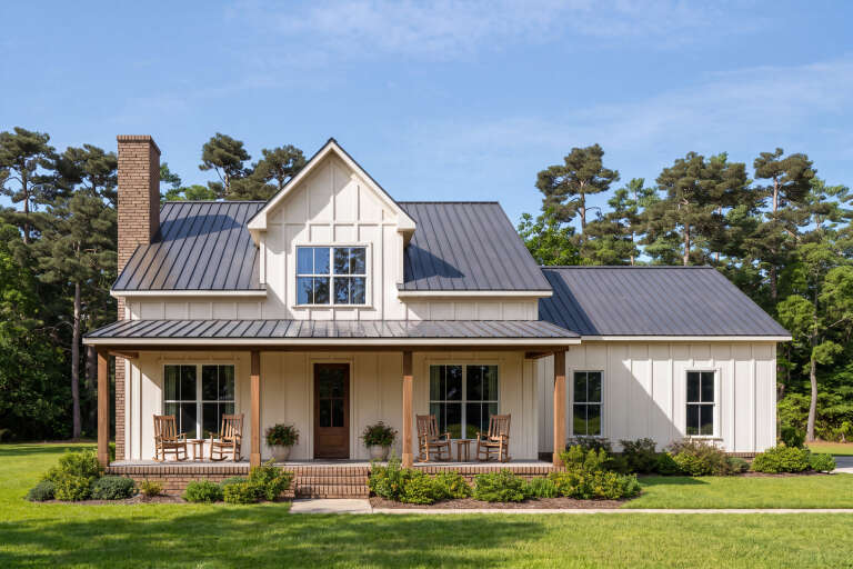 Front view of a cream house in Modern Farmhouse style, metal roof, board-and-batten siding, and covered porch. House Plan # 7568-00073