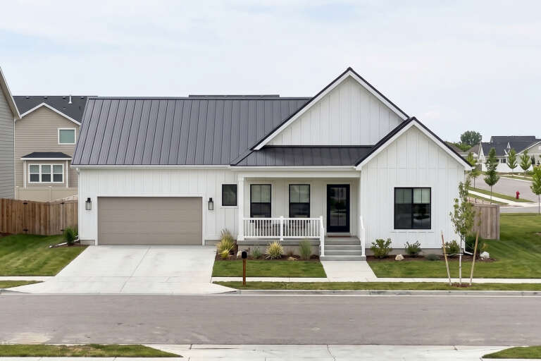 Front view of a white house in Modern Farmhouse style, metal roof, board-and-batten siding, and covered front porch. House Plan # 963-01355